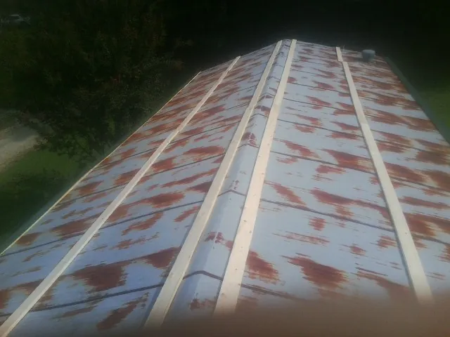 Rusted metal roof panels with new wood purlins before replacement — Storm Damage Roof Repair in Red Springs by Roofing Brothers