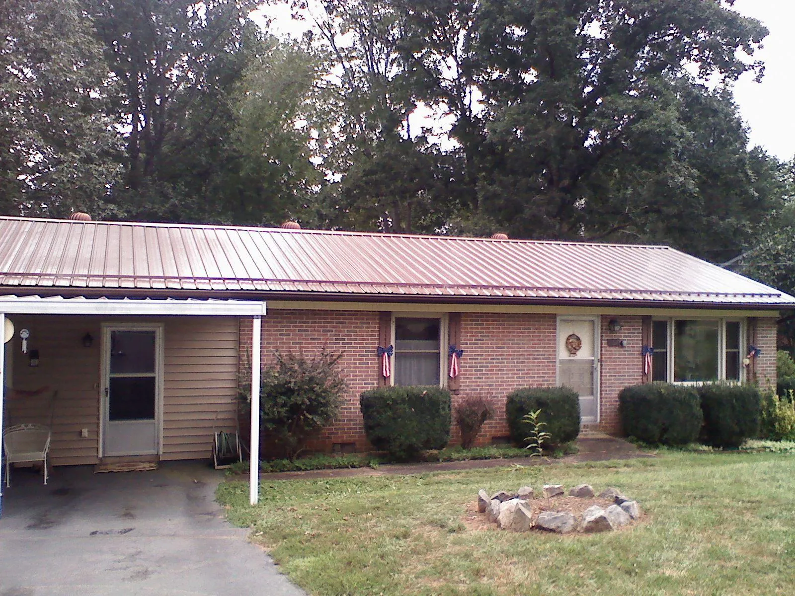 Bronze metal roof and carport on a brick ranch home — Roof Repair work by our crew in Red Springs