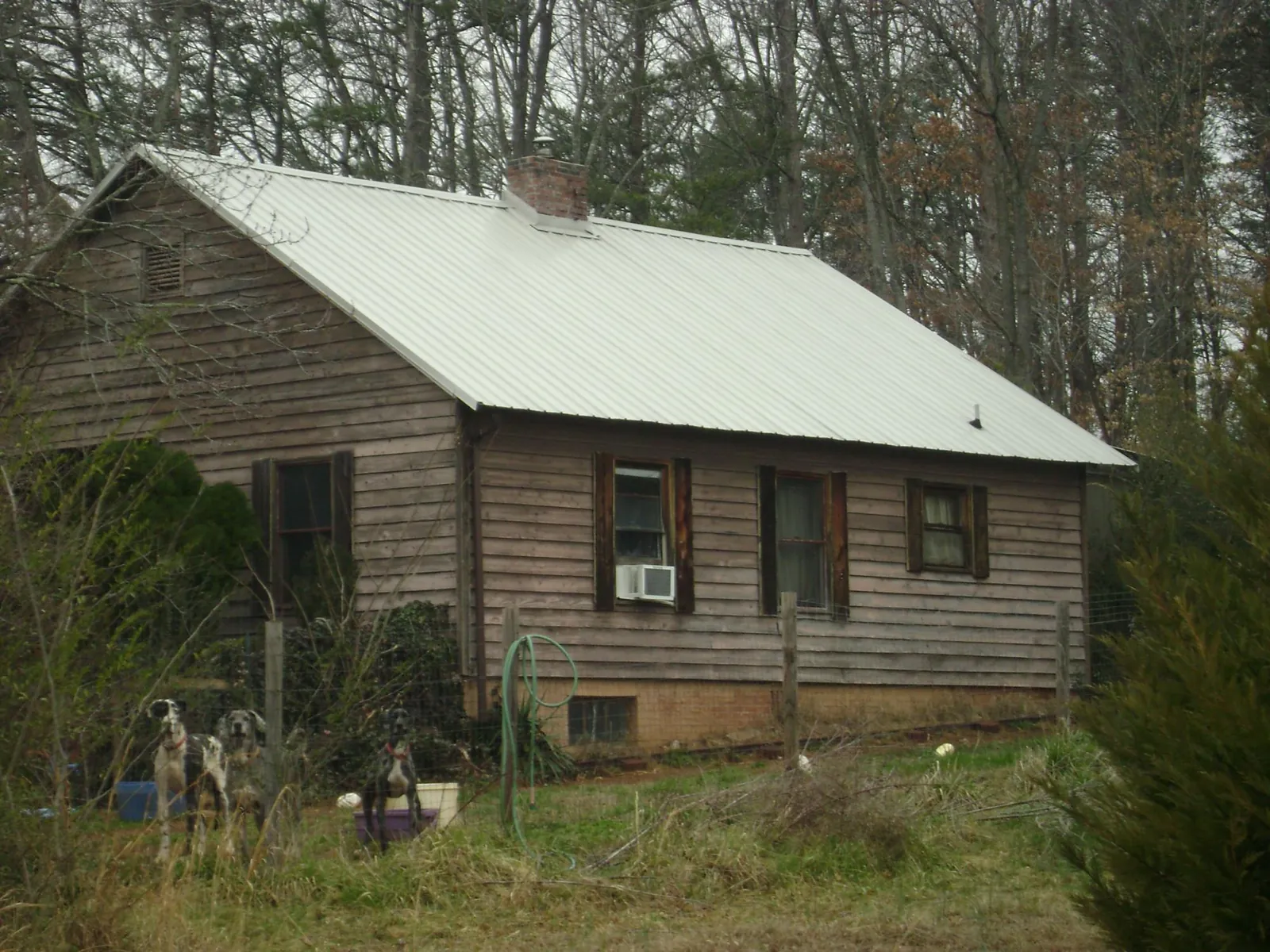 White metal roof on an old wood sided farmhouse, from a Metal Roof Installation job in Red Springs